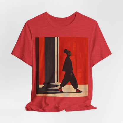 Unisex shirt featuring a Black woman with an afro puff walking past a red wall, dressed in all black with red sneakers.