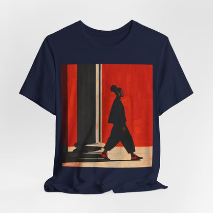 Unisex shirt featuring a Black woman with an afro puff walking past a red wall, dressed in all black with red sneakers.