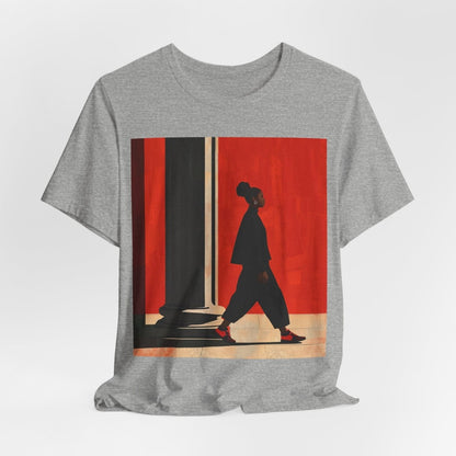 Unisex shirt featuring a Black woman with an afro puff walking past a red wall, dressed in all black with red sneakers.